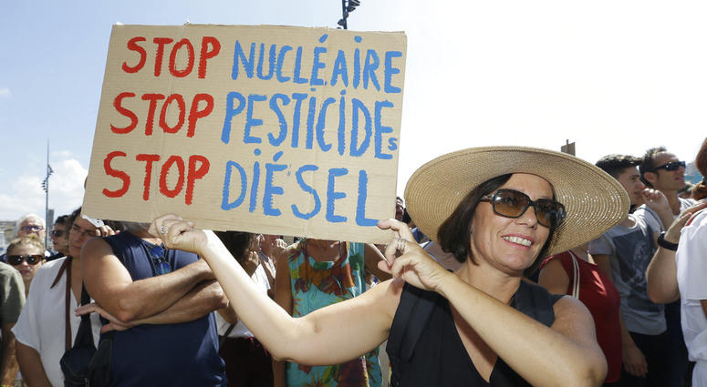 A woman holds a placard reading "Stop nuclear, Stop pesticides, Stop diesel", during a demonstration for the climate in Marseille, southern France, DO NOT USE