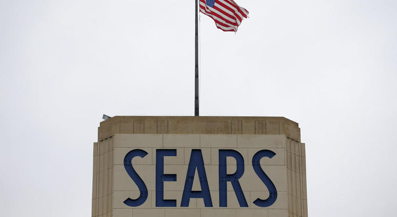 An American flag flies above a Sears department store sign in Hackensack, N.J., Monday, Oct. 15, 2018. Sears filed for Chapter 11 bankruptcy protection Monday, buckling under its massive debt load and staggering losses. DO NOT USE