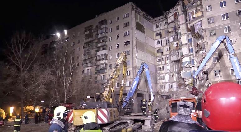 This photo provided by the Russian Emergency Situations Ministry taken from tv footage shows Emergency Situations employees work at the scene of a collapsed section of an apartment building, in Magnitigorsk, DO NOT USE