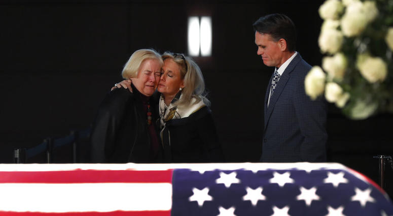 Rep. Debbie Dingell, D-Mich., center, consoles former Rep. Candice Miller, R-Mich., as Macomb County executive Mark Hackel, right, looks on at the casket of her husband and former Rep. John Dingell, lying in repose in Dearborn, Mich., Monday, Feb. 11, 201 Rep. Debbie Dingell, D-Mich., center, consoles former Rep. Candice Miller, R-Mich., as Macomb County executive Mark Hackel, right, looks on at the casket of her husband and former Rep. John Dingell, lying in repose in Dearborn, Mich., Monday, Feb. 11, 201