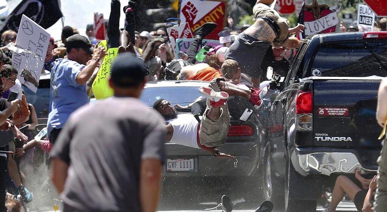 people fly into the air as a vehicle is driven into a group of protesters demonstrating against a white nationalist rally in Charlottesville, Va. AP DO NOT USE