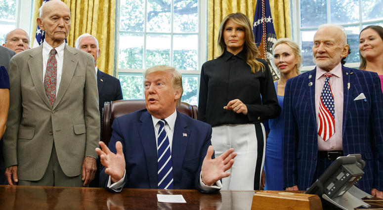 President Donald Trump, accompanied by Apollo 11 astronauts Michael Collins, left, and Buzz Aldrin, right, with Vice President Mike Pence and first lady Melania Trump, speaks during a photo opportunity commemorating the 50th anniversary of the Apollo 11