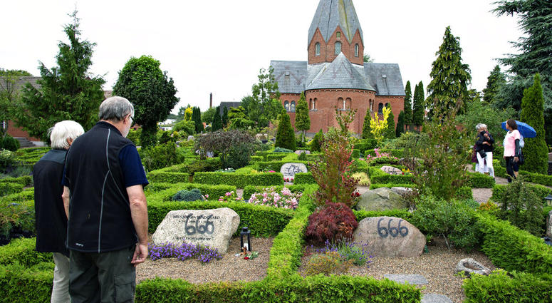 People look at a vandalised tombstone at Hadsund Cemetery, in eastern Jutland, Denmark AP DO NOT USE