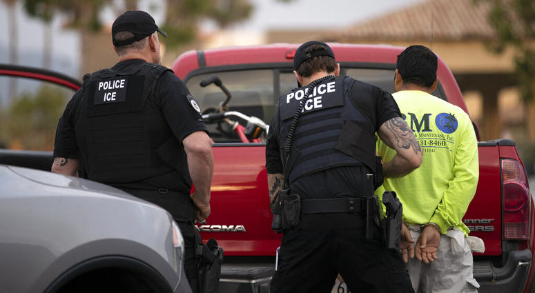 In this July 8, 2019 file photo, U.S. Immigration and Customs Enforcement (ICE) officers detain a man during an operation in Escondido, Calif AP DO NOT USE