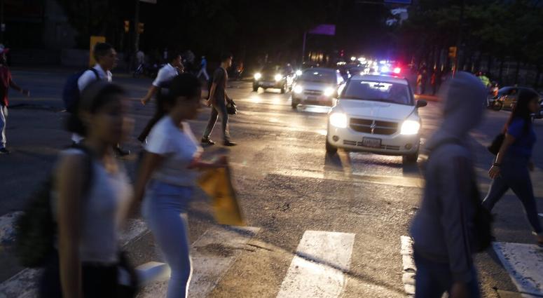 People cross a street during a blackout in Caracas, Venezuela, Monday, July 22, 2019. AP DO NOT USE