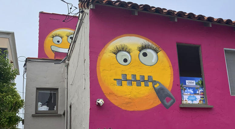 Painted emoji are seen on a house in Manhattan Beach, Calif. on Wednesday, Aug. 7, 2019. The Southern California seaside community is in an uproar after the home was given the new paint job featuring two huge emojis on a bright pink background. Manhattan