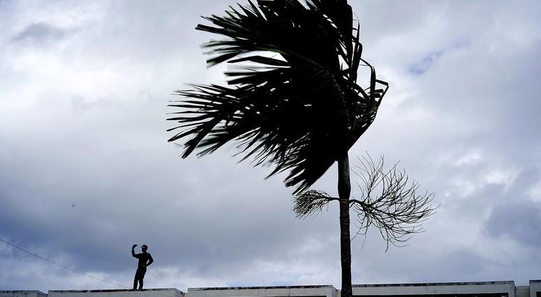 A man stands on a store's roof as he works to prepare it for the arrival of Hurricane Dorian in Freeport on Grand Bahama, Bahamas, A man stands on a store's roof as he works to prepare it for the arrival of Hurricane Dorian in Freeport on Grand Bahama, Bahamas,