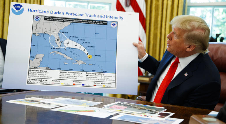 President Donald Trump holds a chart as he talks with reporters after receiving a briefing on Hurricane Dorian in the Oval Office of the White House, Wednesday, Sept. 4, 2019, in Washington.