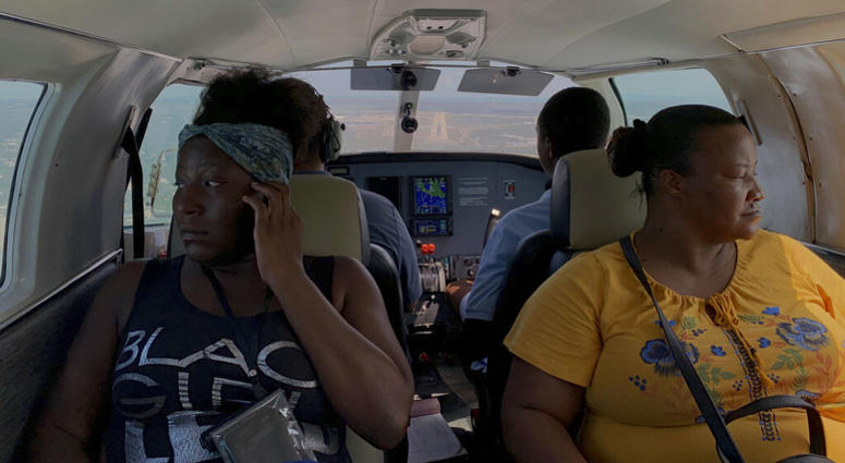 Dimple Lightbourne, left, and her mother Carla Ferguson sit in a plane as it approaches to land in Nassau after they were evacuated from Abaco Island, in the Bahamas, Monday, Sept. 9, 2019. AP DO NOT USE