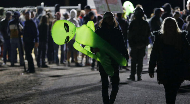 A mans holds an inflatable alien at an entrance to the Nevada Test and Training Range near Area 51 Friday, Sept. 20, 2019, near Rachel, Nev. AP DO NOT USE