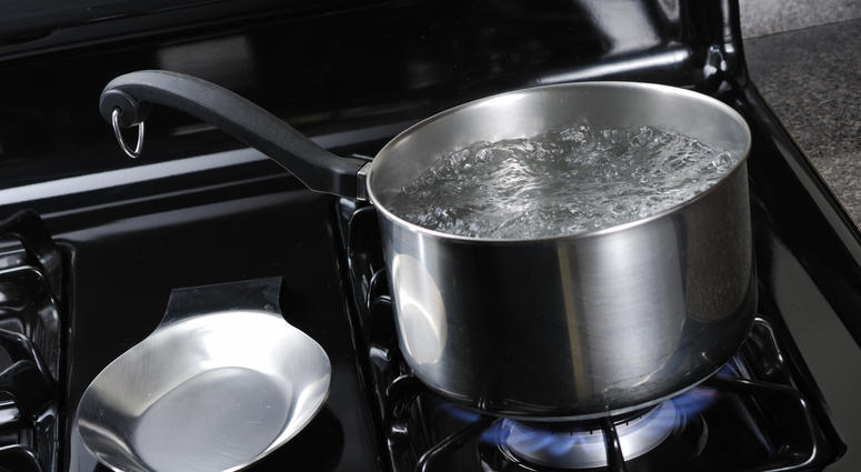 Pot of water boiling on a black natural gas stove. Pot of water boiling on a black natural gas stove.