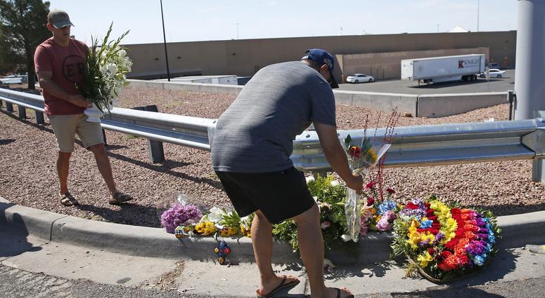 Alfredo Angcayan (right) lay flowers outside Walmart in El Paso