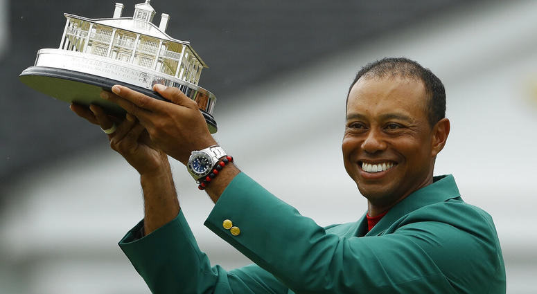 Tiger Woods wears his green jacket holding the winning trophy after the final round for the Masters golf tournament Sunday, April 14, 2019, in Augusta, Ga. AP DO NOT USE