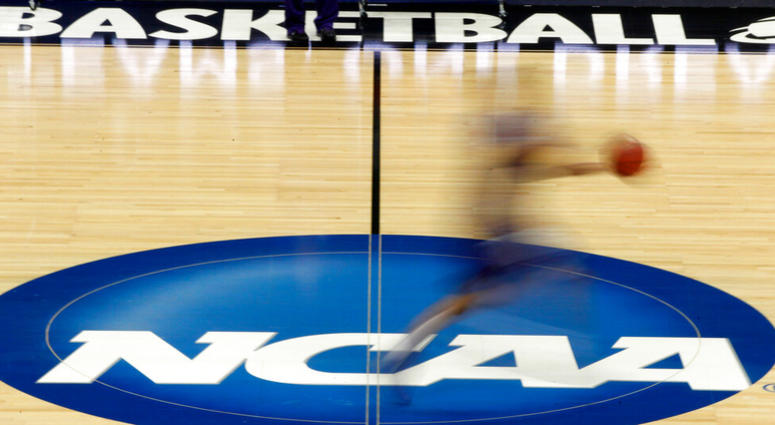 a player runs across the NCAA logo during practice at the NCAA tournament college basketball in Pittsburgh a player runs across the NCAA logo during practice at the NCAA tournament college basketball in Pittsburgh
