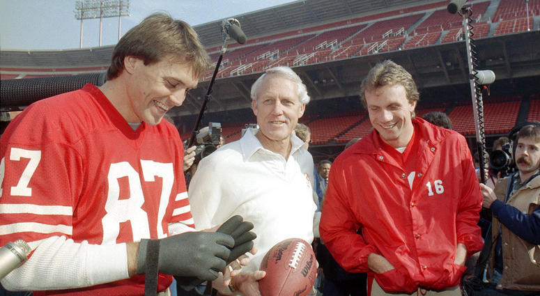 In this Jan. 16, 1985, file photo, San Francisco 49ers' head coach Bill Walsh, center, laughs with quarterback Joe Montana (16) and receiver Dwight Clark, left, at San Francisco's Candlestick Park. DO NOT USE