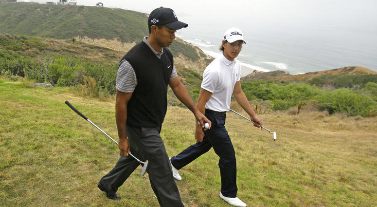 Tiger Woods, left, walks with amateur Jordan Cox along the cliff between the third and fourth holes at Torrey Pines during a practice round for the U.S. Open golf tournament in San Diego DO NOT USE
