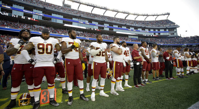 Washington Redskins players stand for the national anthem before a preseason NFL football game against the New England Patriots, Thursday, Aug. 9, 2018, in Foxborough, Mass. DO NOT USE