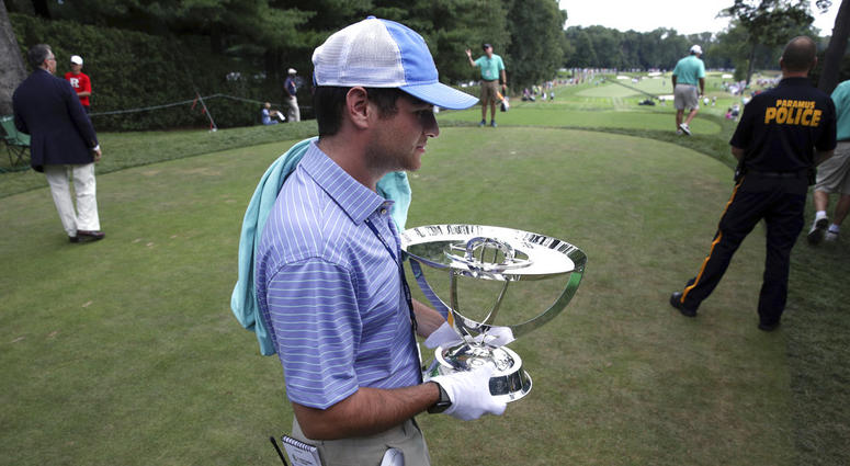 Zach Rosen carries the winner's trophy from the first tee box during the final round of the Northern Trust golf tournament, Sunday, Aug. 26, 2018, in Paramus, N.J. DO NOT USE