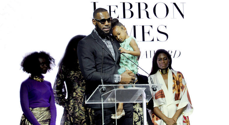 Basketball star LeBron James, holds his daughter Zhuri, as he accepts the Harlem Fashion Row's ICON 360 Award for his contribution to fashion and philanthropy at the HFR fashion show and awards ceremony before the start of New York Fashion Week DO NOT USE