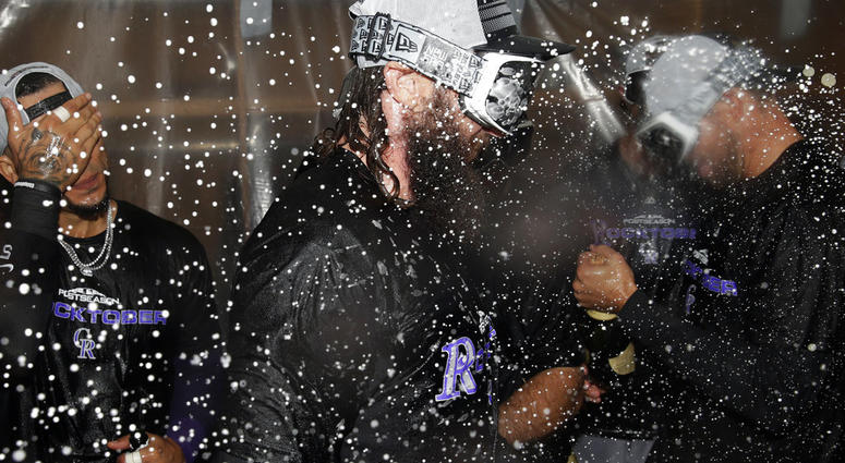 Colorado Rockies' Charlie Blackmon celebrates with teammates in the club house after defeating the Chicago Cubs 2-1 in the National League wild-card playoff baseball game early Wednesday, Oct. 3, 2018, in Chicago. DO NOT USE