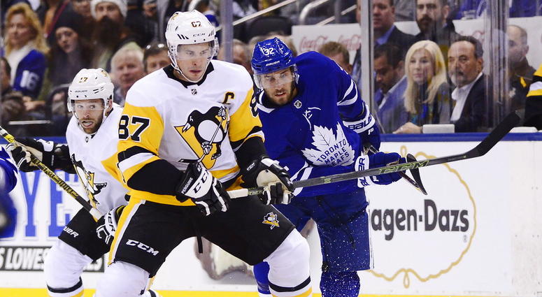 pittsburgh Penguins center Sidney Crosby (87) and Toronto Maple Leafs left wing Josh Leivo (32) battle for the puck during first period NHL hockey action in Toronto on Thursday, Oct. 18, 2018. DO NOT USE