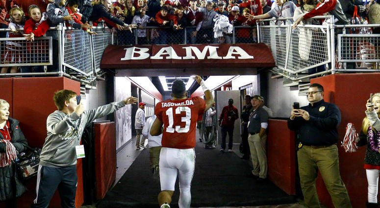 Alabama quarterback Tua Tagovailoa (13) waves to fans as he runs off the field Alabama quarterback Tua Tagovailoa (13) waves to fans as he runs off the field