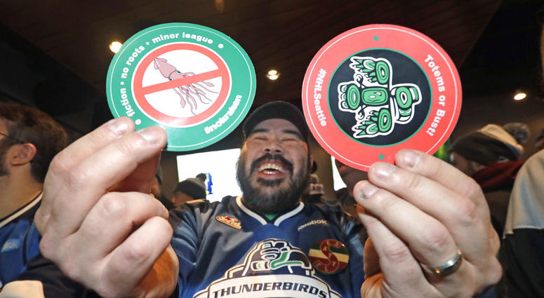 Otto Rogers playfully holds up stickers against the proposed name Kraken and in support of Totems following the announcement of a new NHL hockey team in Seattle, at a celebratory party Tuesday, Dec. 4, 2018, in Seattle DO NOT USE