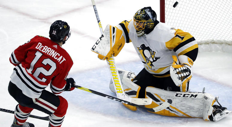 Chicago Blackhawks left wing Alex DeBrincat, left, scores against Pittsburgh Penguins goalie Casey DeSmith Chicago Blackhawks left wing Alex DeBrincat, left, scores against Pittsburgh Penguins goalie Casey DeSmith