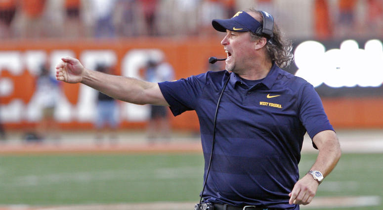 In this Nov. 3, 2018, file photo, West Virginia head coach Dana Holgorsen calls out to his team during the second half of an NCAA college football game against Texas DO NOT USE