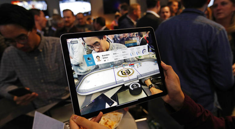 People watch real-time puck and player tracking technology on display during an NHL hockey game between the Vegas Golden Knights and the San Jose Sharks AP DO NOT USE