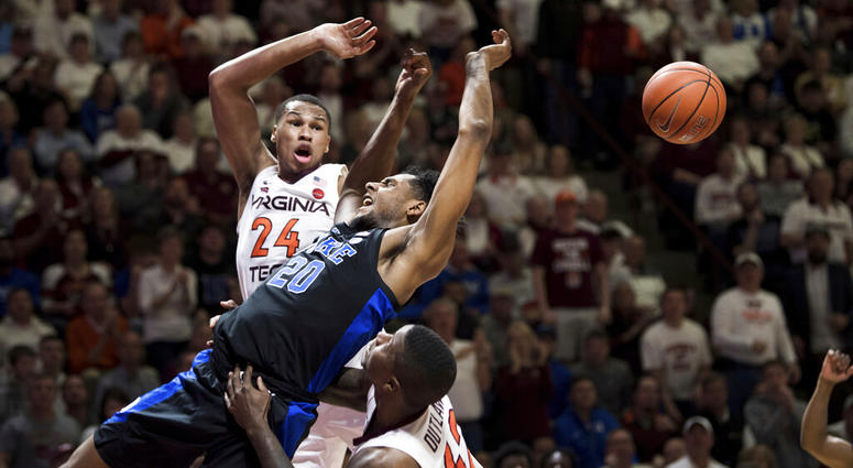 Duke center Marques Bolden (20) is fouled as Virginia Tech's Kerry Blackshear Jr. (24) and Ty Outlaw (42) defend during the first half of an NCAA college basketball game in Blacksburg, Va., Tuesday, Feb. 26, 2019. DO NOT USE