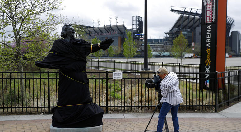 A television photographer records the partially covered statue of singer Kate Smith near the Wells Fargo Center, Friday, April 19, 2019, in Philadelphia. AP DO NOT USE