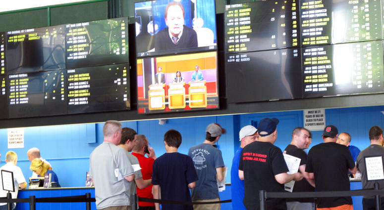 In this June 19, 2018, file photo, sports bettors line up at windows at Monmouth Park racetrack in Oceanport, N.J. AP DO NOT USE