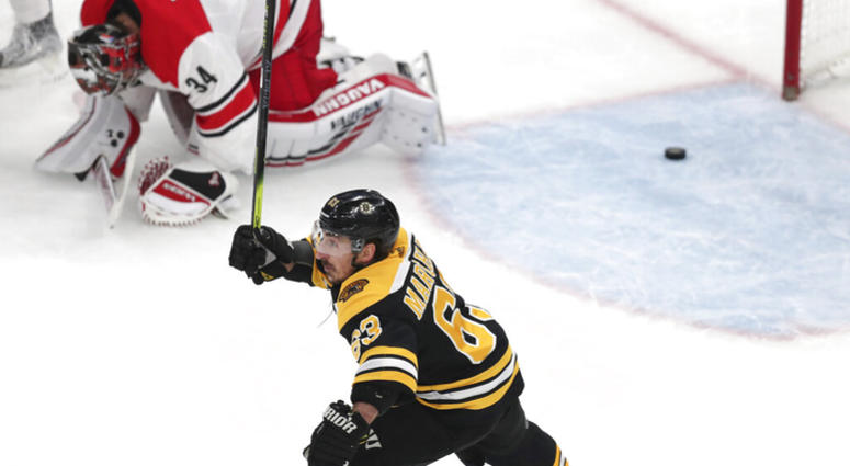 Boston Bruins' Brad Marchand (63) raises his stick as Carolina Hurricanes goaltender Petr Mrazek (34), of the Czech Republic, drops to the ice after a goal by Patrice Bergeron during the third period in Game 1 of the NHL hockey Stanley Cup Eastern Confere AP DO NOT USE