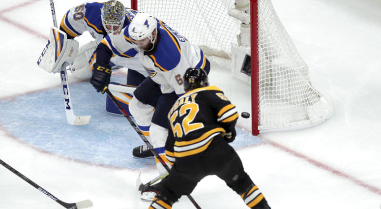Boston Bruins' Sean Kuraly (52) scores a goal past St. Louis Blues goaltender Jordan Binnington (50) and Joel Edmundson (6) during the third period in Game 1 of the NHL hockey Stanley Cup Final, Monday, May 27, 2019, in Boston. ap do not use