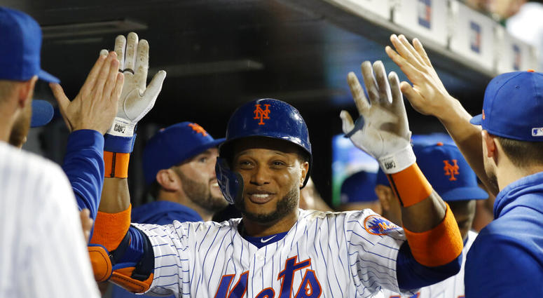 Teammates in the dugout congratulate New York Mets' Robinson Cano after the third of Cano's three home runs AP DO NOT USE