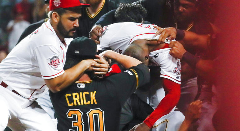 Pittsburgh Pirates' Kyle Crick (30) and Cincinnati Reds' Eugenio Suarez, left, and Amir Garrett, center right, are part of a brawl during the ninth inning of a baseball game Tuesday, July 30, 2019, in Cincinnati.