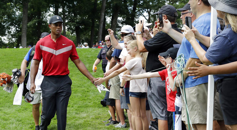 Tiger Woods, left, greets fans as he walks to the 14th fairway after hitting his tee shot during the final round of the BMW Championship golf tournament at Medinah Country Club, Sunday, Aug. 18, 2019, in Medinah, Ill. Tiger Woods, left, greets fans as he walks to the 14th fairway after hitting his tee shot during the final round of the BMW Championship golf tournament at Medinah Country Club, Sunday, Aug. 18, 2019, in Medinah, Ill.