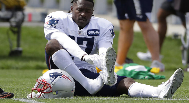 New England Patriots wide receiver Antonio Brown puts on his shoe during an NFL football practice, Wednesday, Sept. 18, 2019, in Foxborough, Mass.