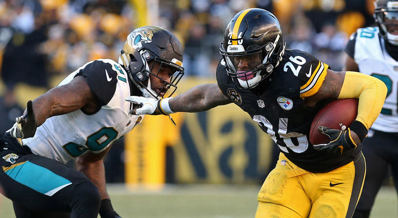 Pittsburgh Steelers running back Le'Veon Bell (26) carries the ball as Jacksonville Jaguars defensive end Yannick Ngakoue (91) chases in the AFC Divisional Playoff game at Heinz Field.