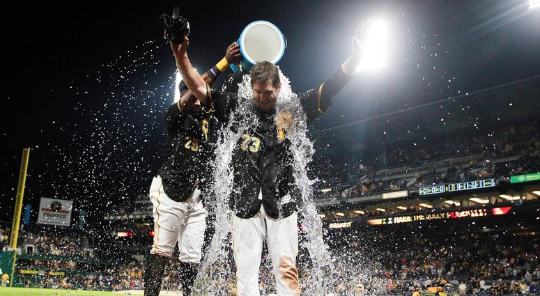 Pittsburgh Pirates first baseman David Freese (23) has water dumped on him by right fielder Gregory Polanco (25) after hitting a walk-off single to win the game against the New York Mets at PNC Park.