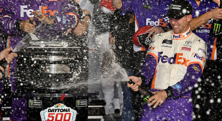 FedEx Joe Gibbs Racing's Denny Hamlin Sprays Champagne On The Harley J. Earl Trophy In Victory Lane At Daytona international Speedway FedEx Joe Gibbs Racing Driver Denny Hamlin Wins Daytona 500