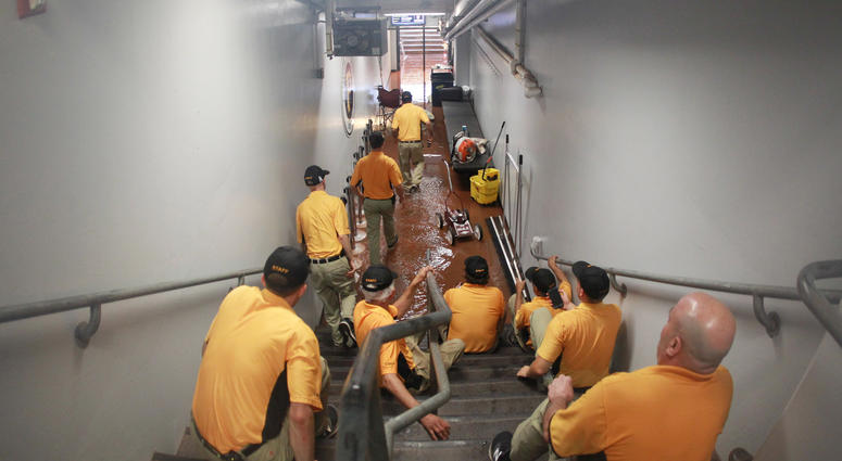 The Pittsburgh Pirates grounds crew take action as rain floods the umpire tunnel during a rain delay of the game between the Milwaukee Brewers and the Pittsburgh Pirates at PNC Park.