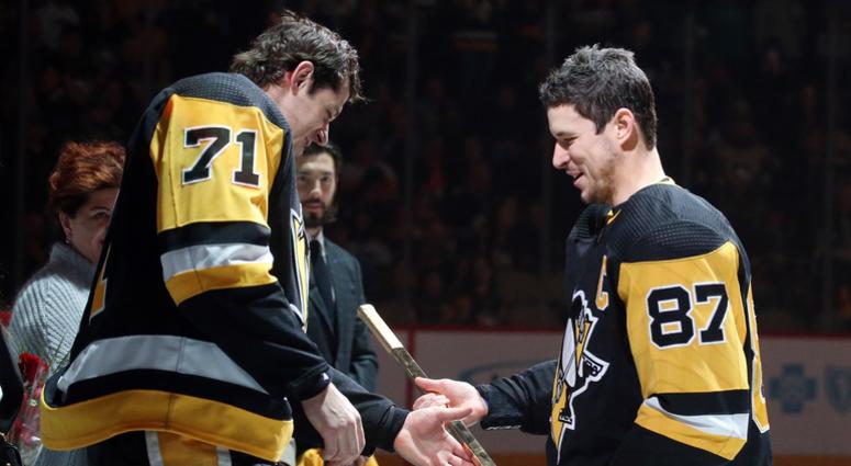 Pittsburgh Penguins center Evgeni Malkin (71) accepts a gold stick from Pittsburgh Penguins center Sidney Crosby