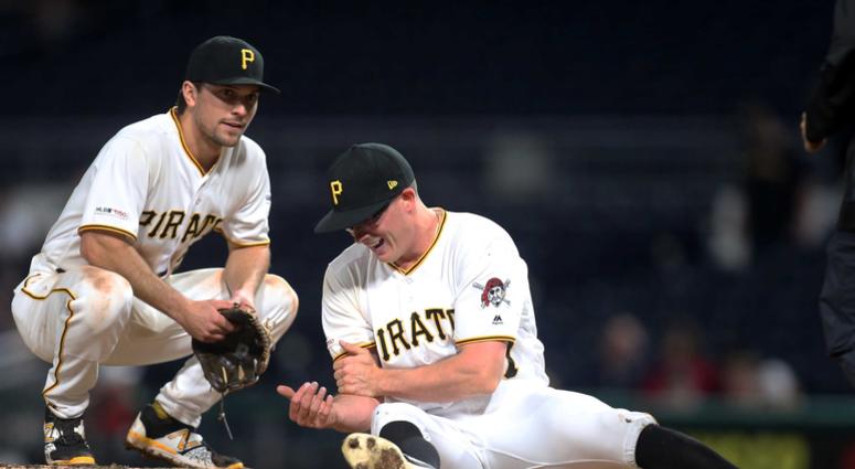 pitcher Nick Burdi (57) grabs his bicep after suffering an injury while pitching as second baseman Adam Frazier (26) looks on