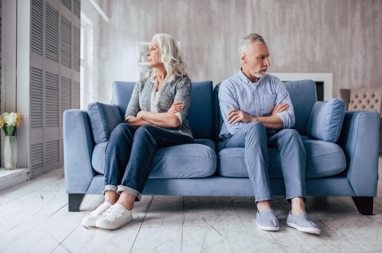 Couple sitting on couch facing away from each other
