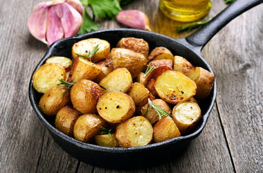 Roasted potato in frying pan - Roasted potato in frying pan on wooden background Roasted potato in frying pan - Roasted potato in frying pan on wooden background