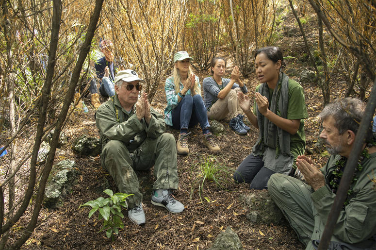 AP19231071522801 In this Friday, Aug. 16, 2019 photo, musician Paul Simon, left, joins in a prayer lead by Aimee Sato, second from right, prior to the planting of a lama tree at Auwahi Forest Reserve on Maui, Hawaii. (Anna Kim/Honolulu Star-Advertiser via AP)