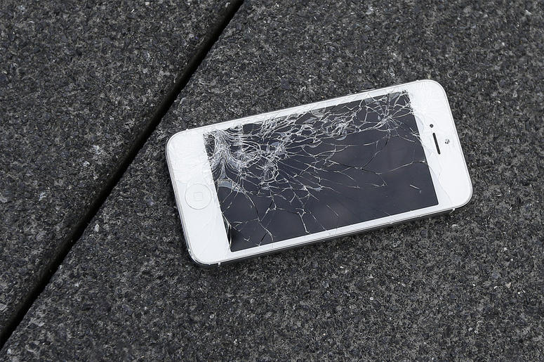 AP19241538579907 This Aug. 26, 2015 photo shows an Apple iPhone with a cracked screen after a drop test from the DropBot, a robot used to measure the sustainability of a phone to dropping, at the offices of SquareTrade in San Francisco. (AP Photo/Ben Margot, File)