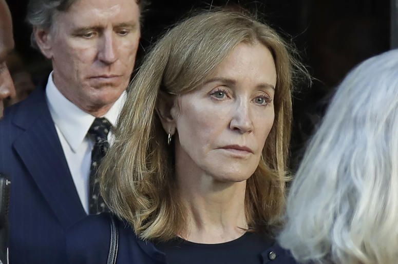 AP19256735150823 Actress Felicity Huffman leaves federal court accompanied by her brother, Moore Huffman Jr., center, after her sentencing in a nationwide college admissions bribery scandal, Friday, Sept. 13, 2019, in Boston. (AP Photo/Elise Amendola)